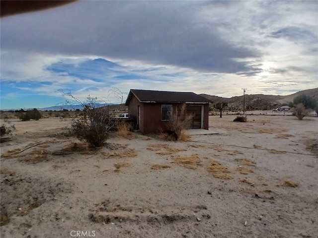 view of outbuilding featuring a garage, a mountain view, and a rural view