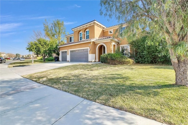 mediterranean / spanish-style house featuring a garage and a front lawn