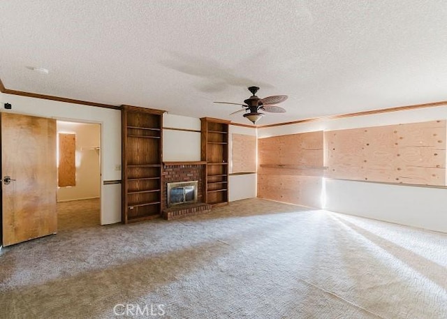 unfurnished living room featuring carpet, a ceiling fan, a fireplace, a textured ceiling, and crown molding