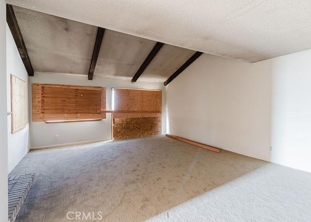 interior space with lofted ceiling with beams, carpet flooring, and a textured ceiling