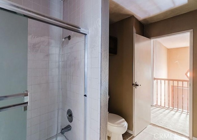 bathroom with shower / bath combination with glass door and toilet