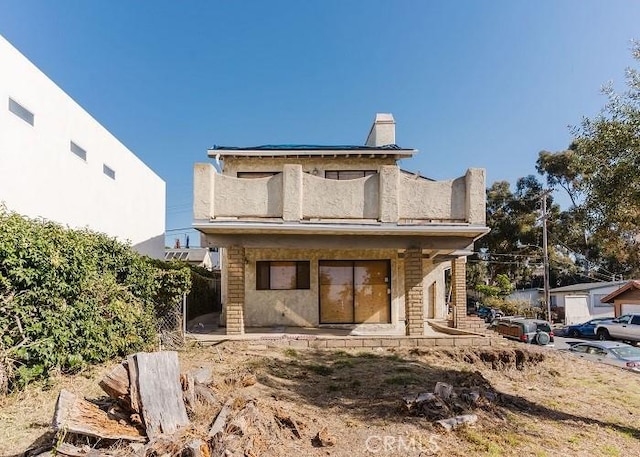 back of property featuring stucco siding and a chimney