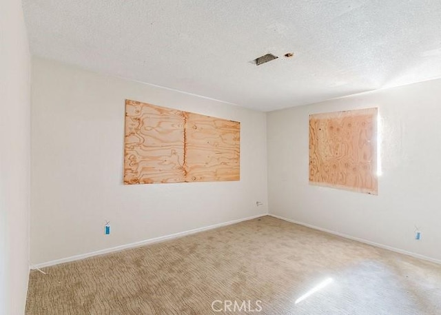 unfurnished room featuring a textured ceiling and carpet flooring