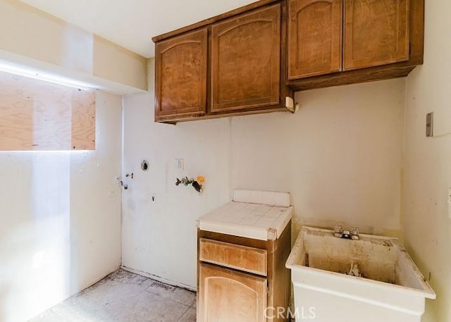 laundry room featuring sink, hookup for a washing machine, and cabinets