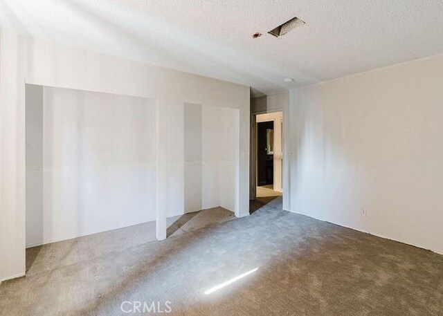 empty room featuring carpet and a textured ceiling