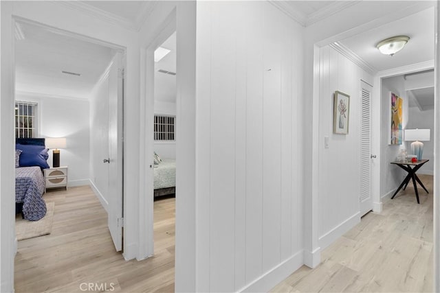 corridor featuring ornamental molding and light wood-type flooring