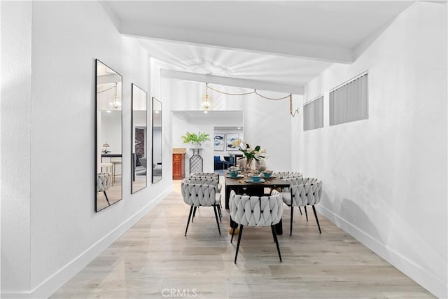 dining area featuring lofted ceiling with beams and light hardwood / wood-style floors