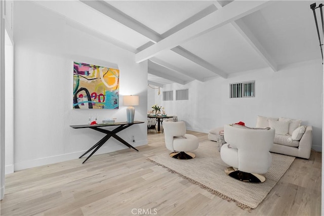 living area featuring beam ceiling and light hardwood / wood-style floors