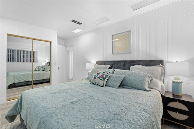 bedroom with wood-type flooring and a closet