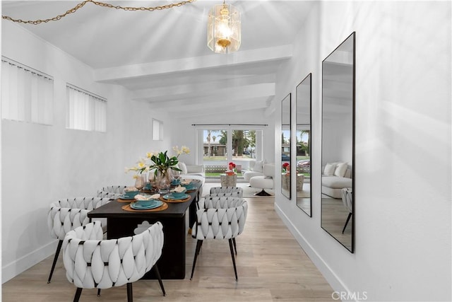 dining room with vaulted ceiling with beams and light wood-type flooring