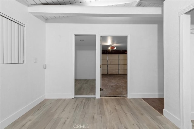 unfurnished bedroom with wood ceiling, beam ceiling, and light hardwood / wood-style floors