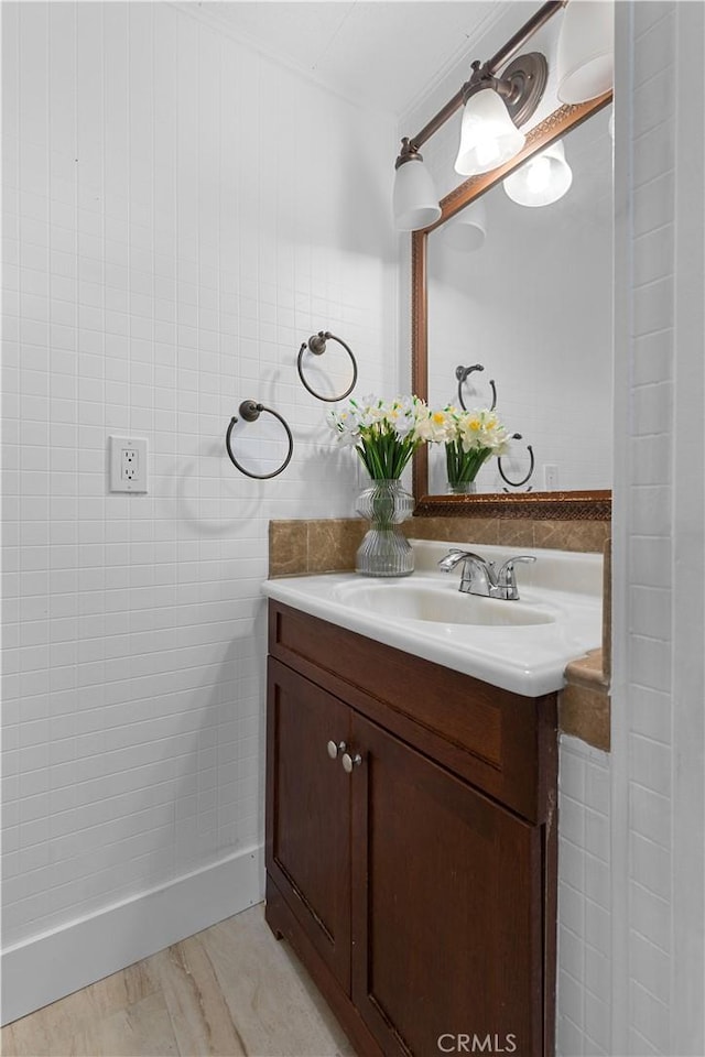 bathroom featuring vanity and tile walls