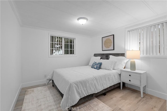 bedroom with ornamental molding and light wood-type flooring