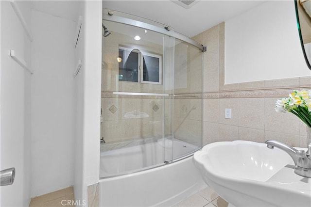 bathroom featuring tile patterned flooring, sink, tile walls, and shower / bath combination with glass door