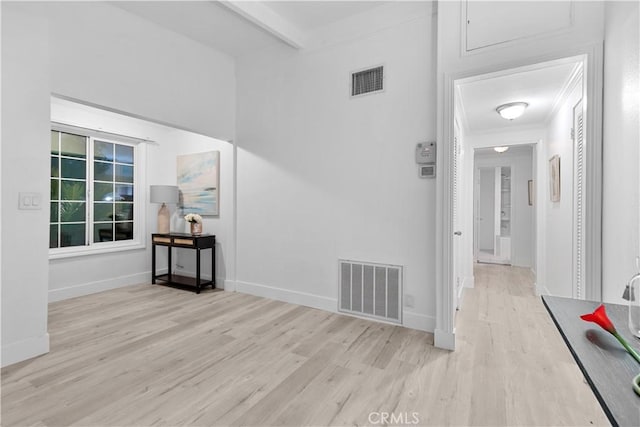 hallway featuring beam ceiling and light hardwood / wood-style flooring