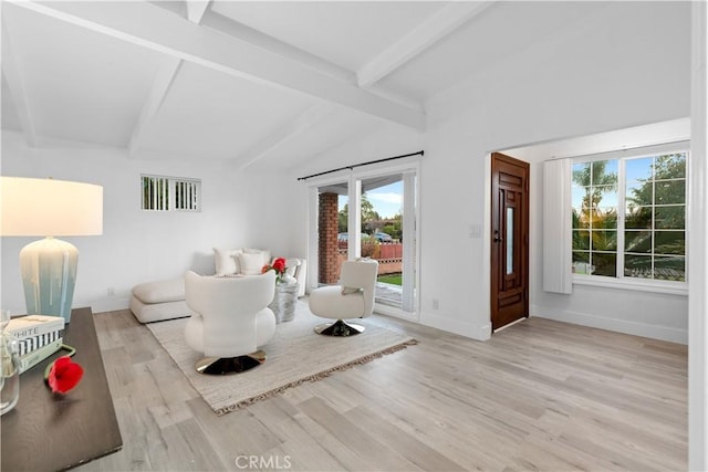 living room with light hardwood / wood-style flooring and lofted ceiling with beams