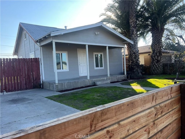 bungalow-style home with a front yard and covered porch