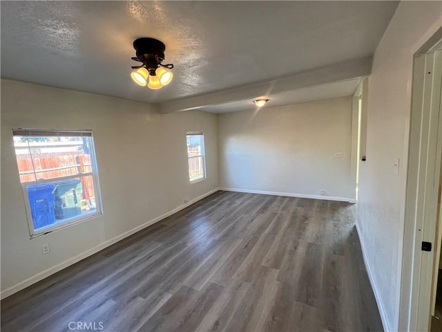 spare room with dark hardwood / wood-style floors and a textured ceiling