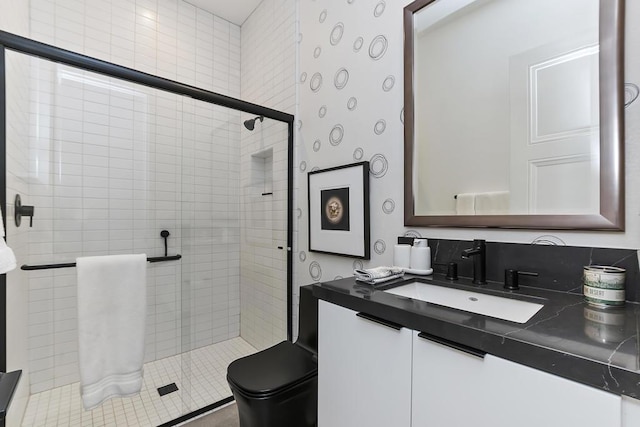 bathroom featuring a shower with door, vanity, and toilet