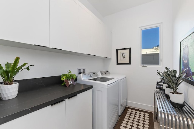 clothes washing area featuring cabinets and washing machine and clothes dryer