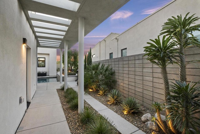 patio terrace at dusk featuring a pergola