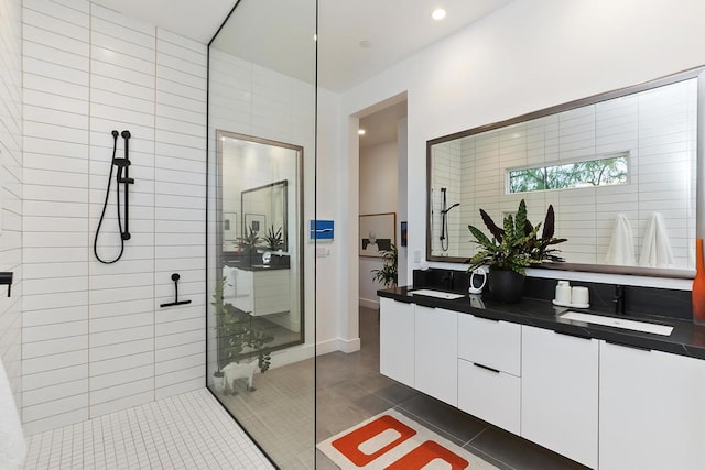 bathroom with tile patterned flooring, vanity, a shower, and tile walls