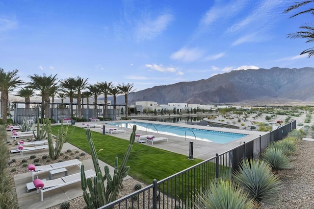 view of swimming pool with a yard, a mountain view, and a patio area