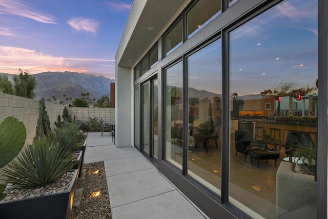 balcony at dusk with a mountain view and a patio area