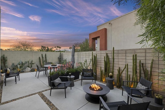 patio terrace at dusk featuring a fire pit