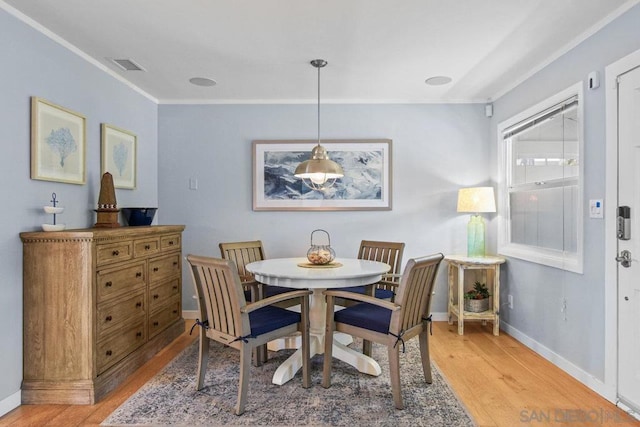 dining area with ornamental molding and hardwood / wood-style floors