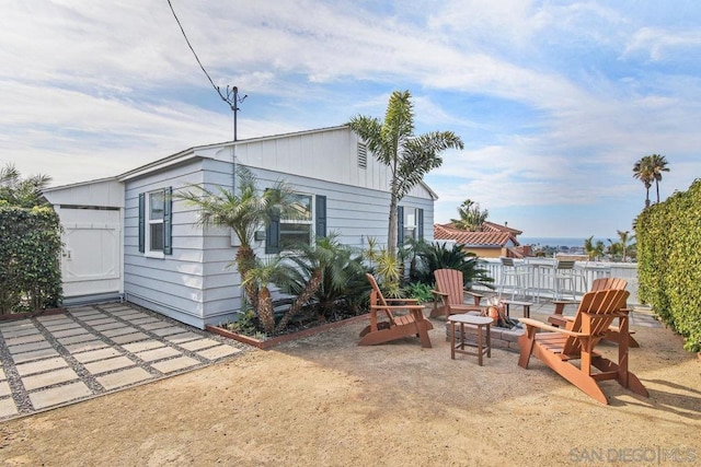 rear view of property with an outdoor fire pit and a patio area