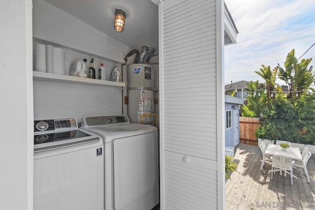 laundry room featuring washer and dryer, hardwood / wood-style floors, and secured water heater