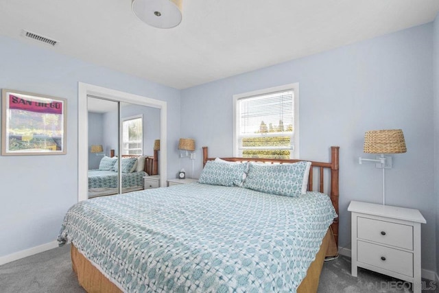 carpeted bedroom featuring multiple windows and a closet