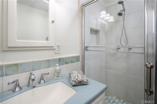 bathroom with vanity, an enclosed shower, and decorative backsplash