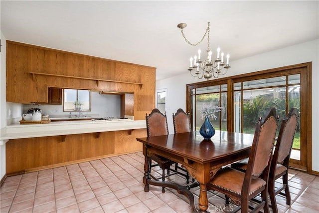 tiled dining space featuring a notable chandelier and a wealth of natural light