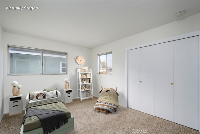 bedroom featuring light colored carpet and a closet