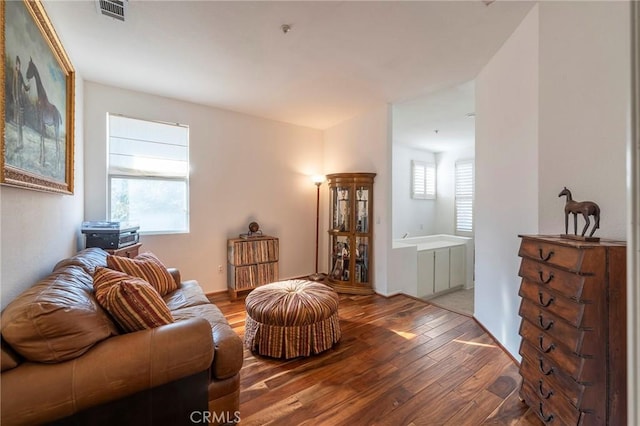 living area with visible vents and wood finished floors