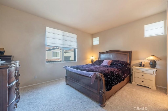 bedroom with light carpet and baseboards