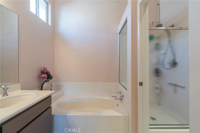 full bathroom featuring a shower stall, a bath, and vanity