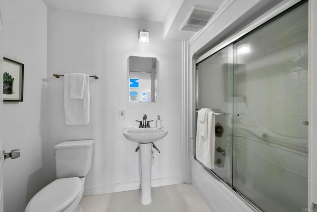 bathroom with enclosed tub / shower combo, tile patterned floors, and toilet