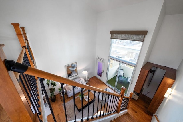 stairs with hardwood / wood-style flooring and a high ceiling