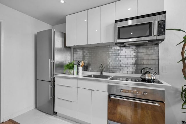 kitchen featuring sink, decorative backsplash, white cabinets, and appliances with stainless steel finishes