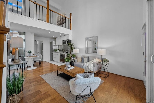 living room featuring light hardwood / wood-style flooring and a high ceiling