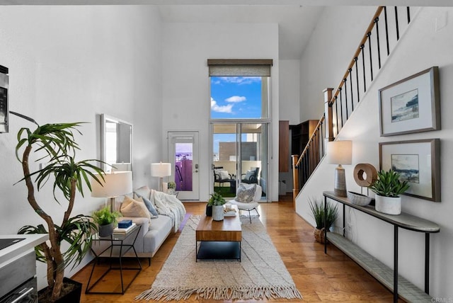 living room featuring light hardwood / wood-style flooring and a high ceiling