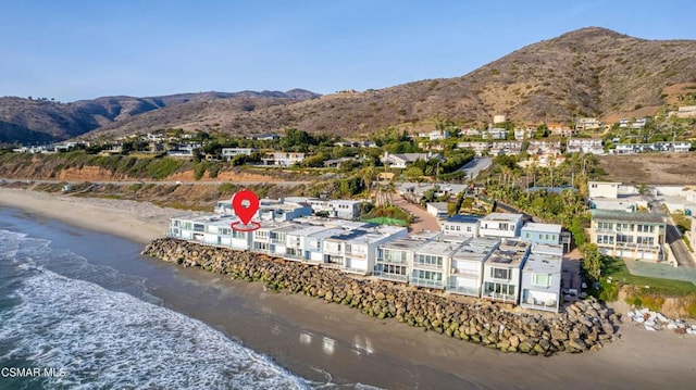 drone / aerial view featuring a view of the beach and a water and mountain view