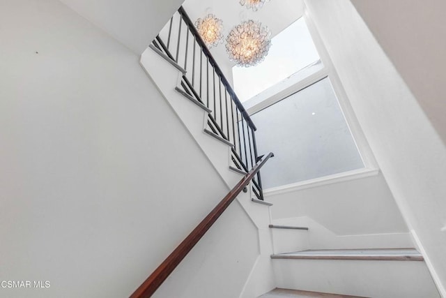 stairs featuring an inviting chandelier