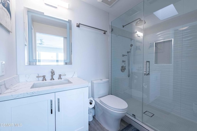 bathroom with vanity, a shower with shower door, hardwood / wood-style floors, and toilet