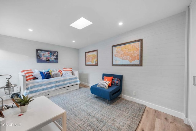 living area with hardwood / wood-style floors and a skylight