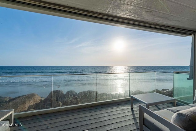 balcony featuring a water view and a beach view