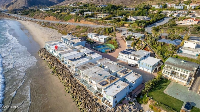 birds eye view of property featuring a water view and a beach view